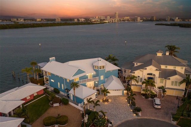 aerial view at dusk featuring a water view