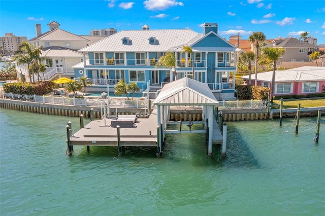 view of dock with a balcony and a water view