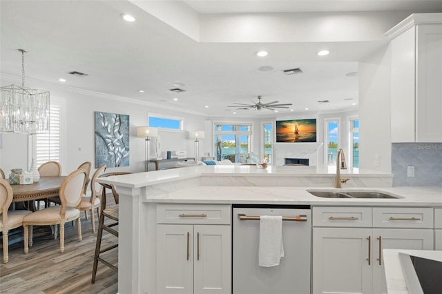 kitchen featuring light stone countertops, white cabinetry, sink, stainless steel appliances, and light wood-type flooring