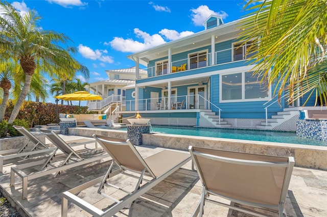 view of swimming pool featuring a patio and an outdoor fire pit