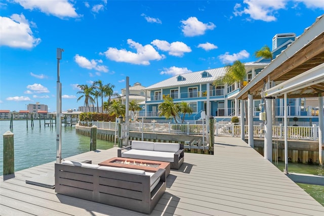 dock area with a water view and a fire pit