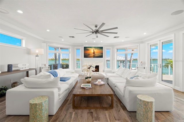 living room with a high end fireplace, hardwood / wood-style flooring, and ornamental molding