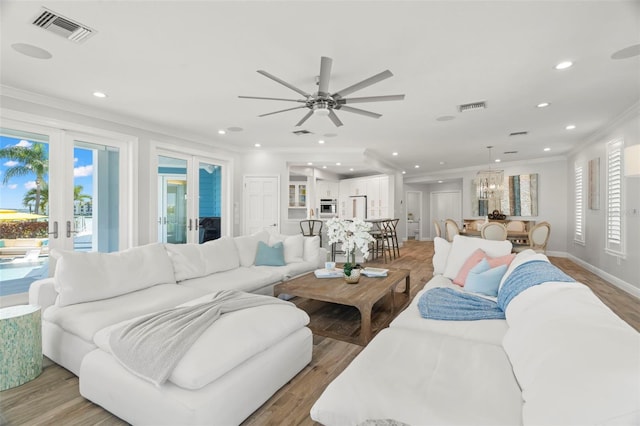 living room with crown molding, ceiling fan, french doors, and light hardwood / wood-style floors