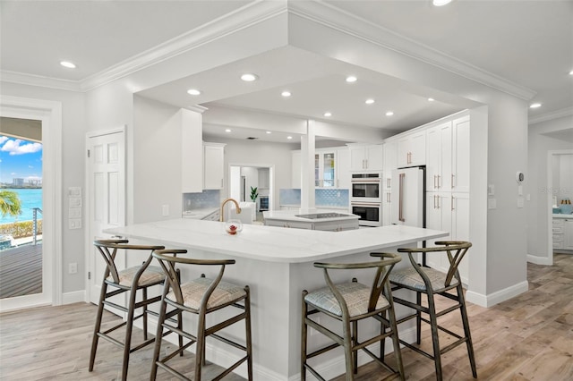 kitchen with white cabinets, kitchen peninsula, a breakfast bar area, and high end white refrigerator