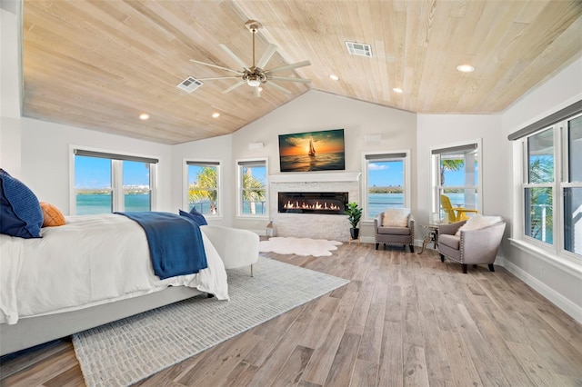 bedroom featuring ceiling fan, light hardwood / wood-style floors, wood ceiling, and multiple windows