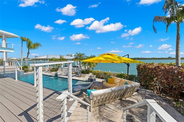 view of pool with an outdoor living space and a water view