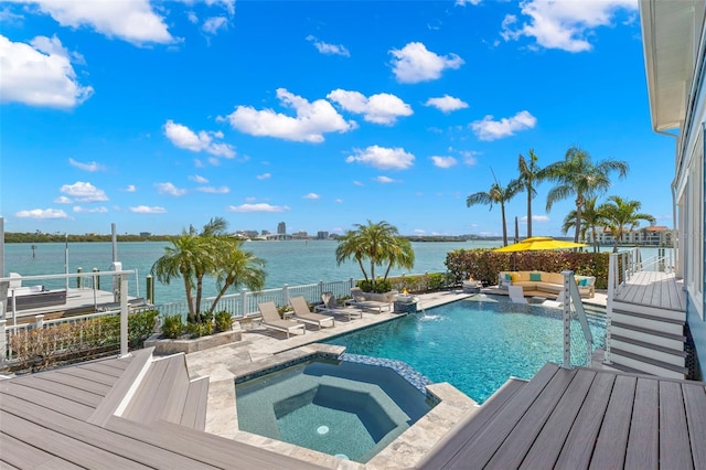 view of pool featuring a patio area, an in ground hot tub, a water view, and pool water feature