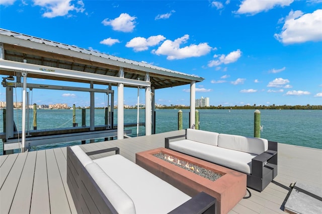 view of dock featuring a water view and an outdoor living space with a fire pit