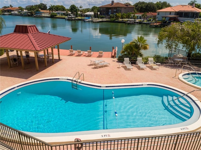 view of swimming pool featuring a gazebo, a water view, and a patio area