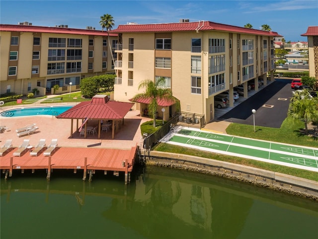 exterior space with a community pool and a water view