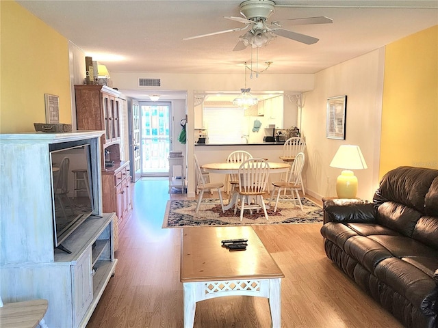 living room with ceiling fan and wood-type flooring