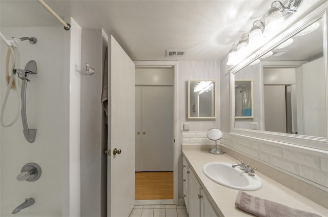 bathroom featuring tile patterned flooring, vanity, backsplash, and shower / bath combination