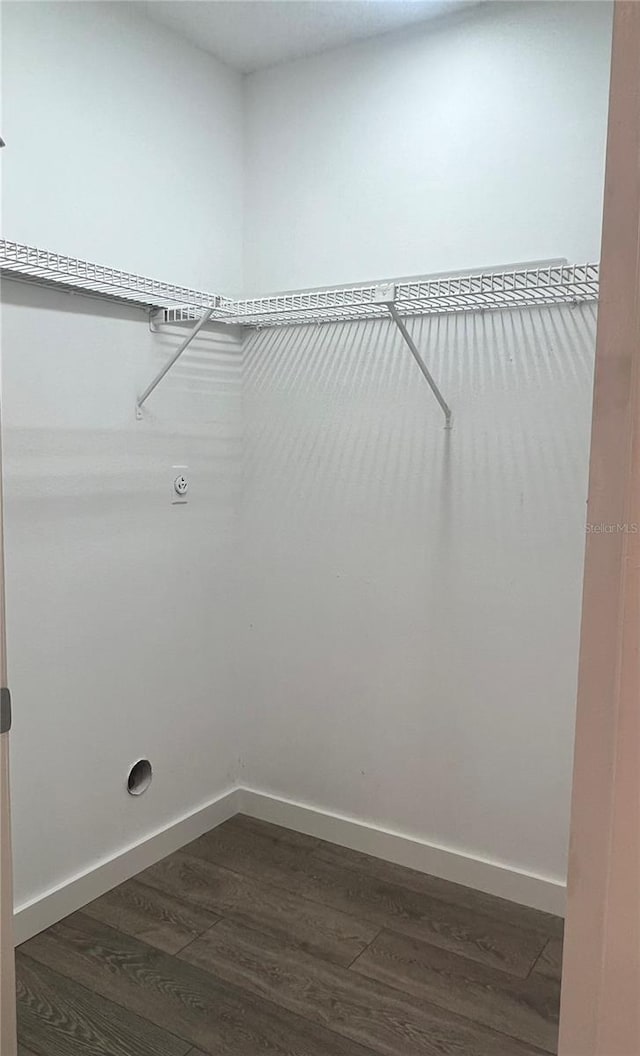 clothes washing area featuring electric dryer hookup and dark wood-type flooring