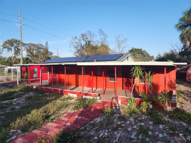 back of property featuring solar panels and a patio