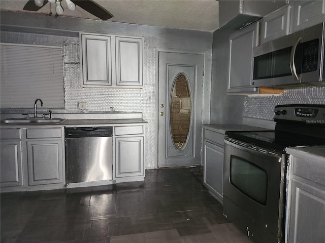 kitchen featuring gray cabinetry, tasteful backsplash, ceiling fan, and appliances with stainless steel finishes