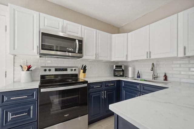 kitchen with white cabinetry, sink, backsplash, and stainless steel appliances