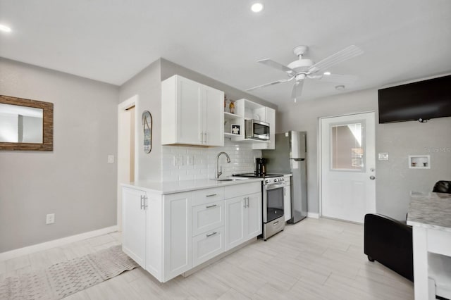 kitchen with ceiling fan, white cabinets, tasteful backsplash, and appliances with stainless steel finishes