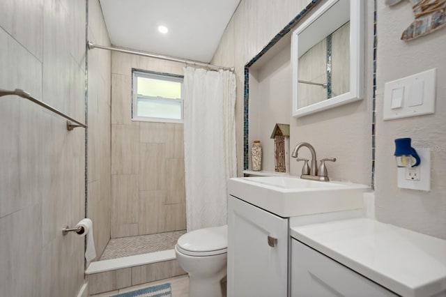 bathroom featuring walk in shower, large vanity, and toilet