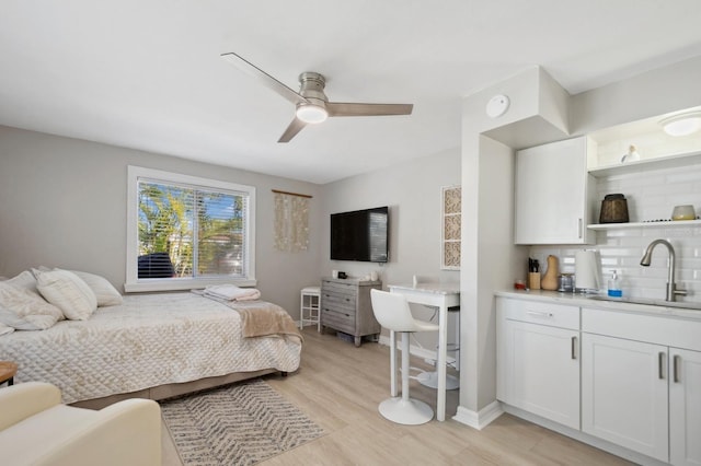 bedroom featuring light hardwood / wood-style floors, sink, and ceiling fan