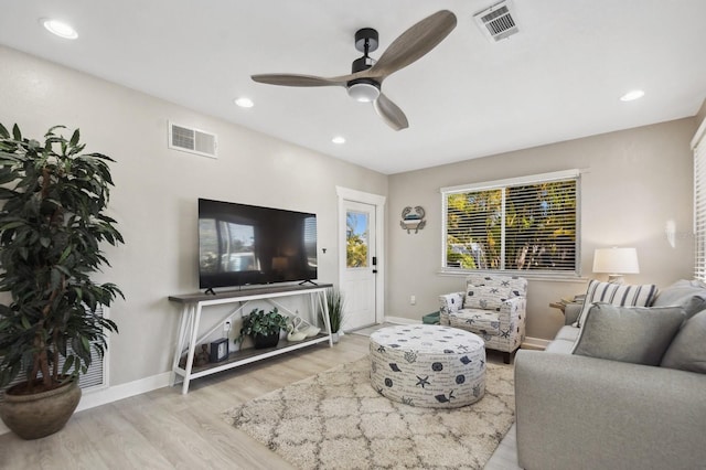 living room featuring light hardwood / wood-style floors and ceiling fan