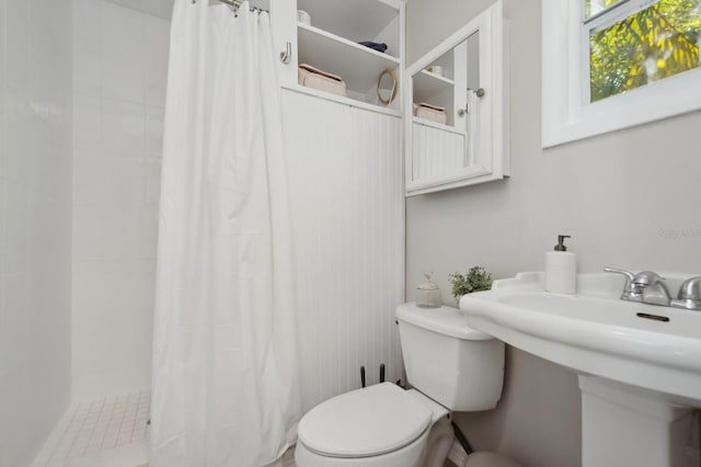 bathroom featuring a shower with shower curtain and toilet