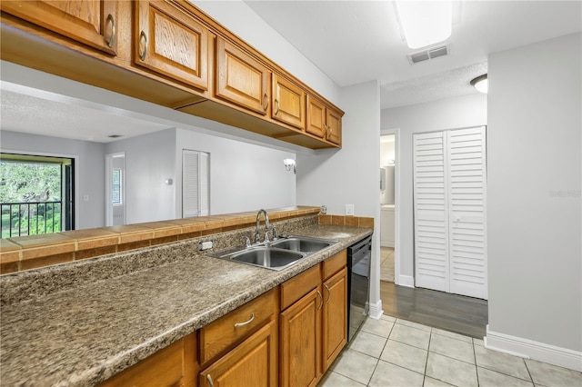 kitchen with black dishwasher, light hardwood / wood-style flooring, and sink