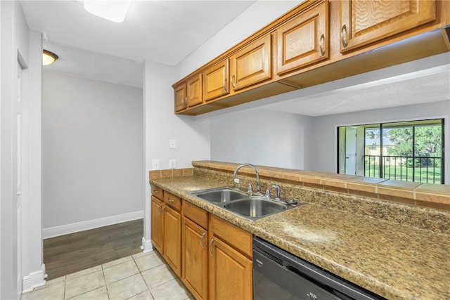 kitchen with dishwashing machine, sink, and light tile floors