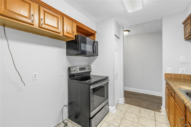 kitchen featuring electric stove and light tile flooring