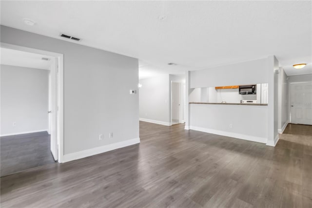 unfurnished living room with dark hardwood / wood-style flooring