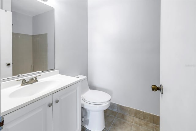 bathroom featuring toilet, tile flooring, and vanity