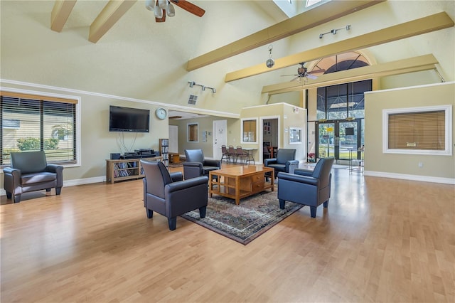 living room featuring plenty of natural light, ceiling fan, a towering ceiling, and beamed ceiling