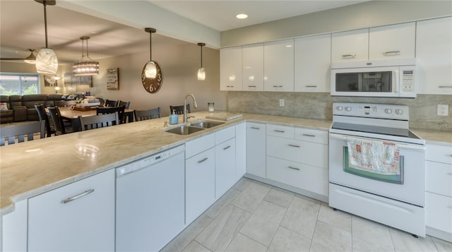 kitchen featuring backsplash, white appliances, sink, white cabinets, and pendant lighting