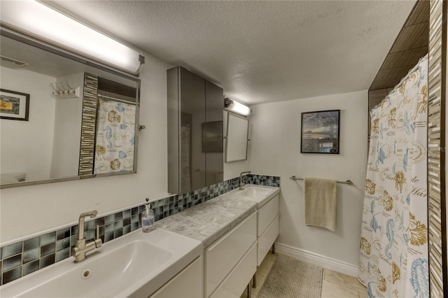 bathroom with large vanity, dual sinks, a textured ceiling, and tile flooring