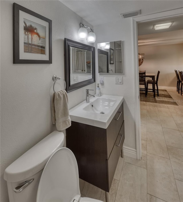 bathroom with toilet, tile floors, and vanity with extensive cabinet space