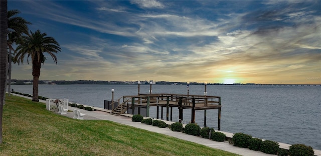 view of dock featuring a water view and a yard