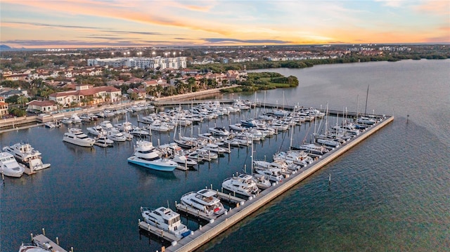 aerial view at dusk featuring a water view