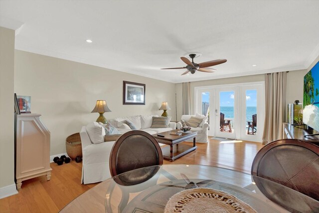 living room with ceiling fan, light wood-type flooring, and crown molding