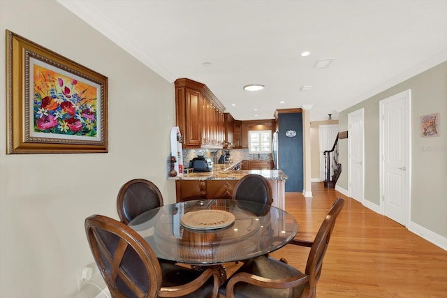 dining area featuring light hardwood / wood-style floors and ornamental molding