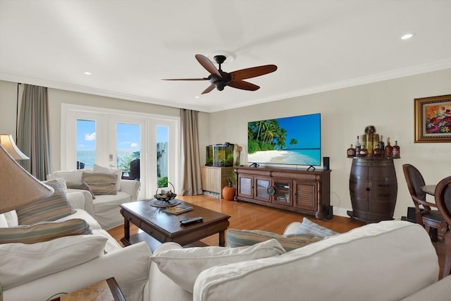 living room with hardwood / wood-style floors, ceiling fan, and crown molding