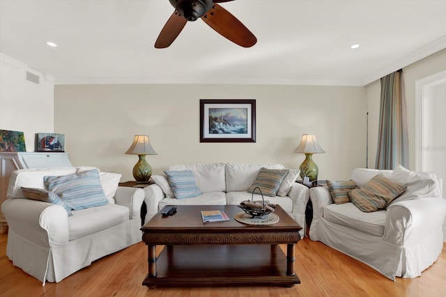 living room featuring ceiling fan, light wood-type flooring, and crown molding