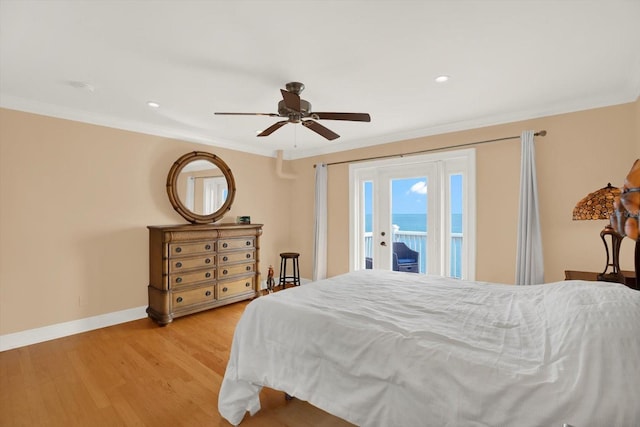 bedroom featuring ceiling fan, light hardwood / wood-style floors, access to outside, a water view, and ornamental molding