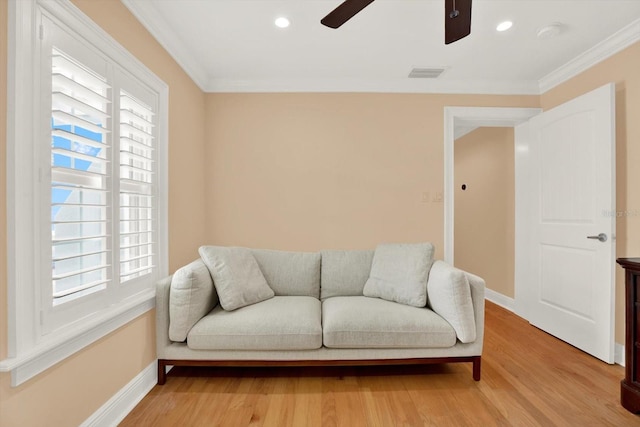 living area featuring crown molding, ceiling fan, and wood-type flooring