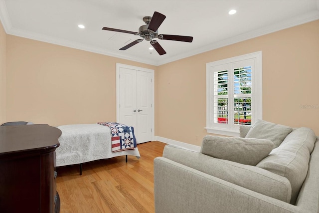 bedroom with a closet, ceiling fan, crown molding, and light hardwood / wood-style floors