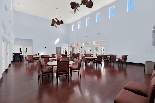 dining room with a towering ceiling and dark hardwood / wood-style floors