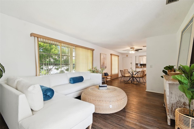 living room featuring ceiling fan and dark hardwood / wood-style floors