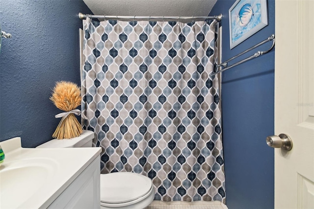 bathroom featuring a textured ceiling, toilet, vanity, and tile patterned floors