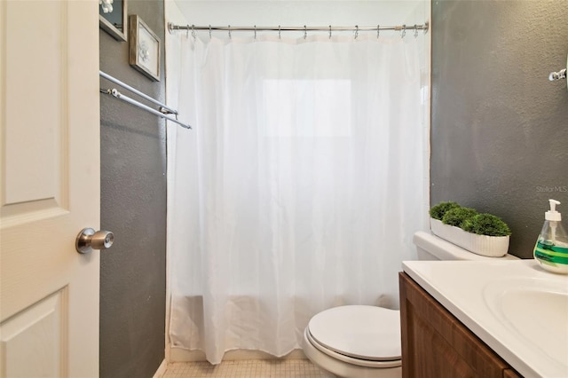 bathroom with toilet, tile patterned floors, and vanity