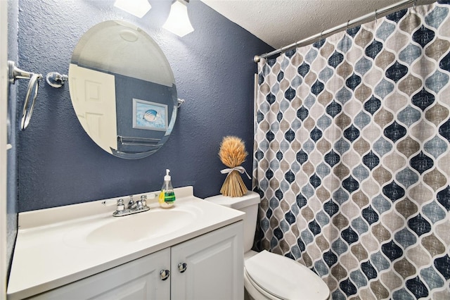 bathroom with toilet, a textured ceiling, and vanity