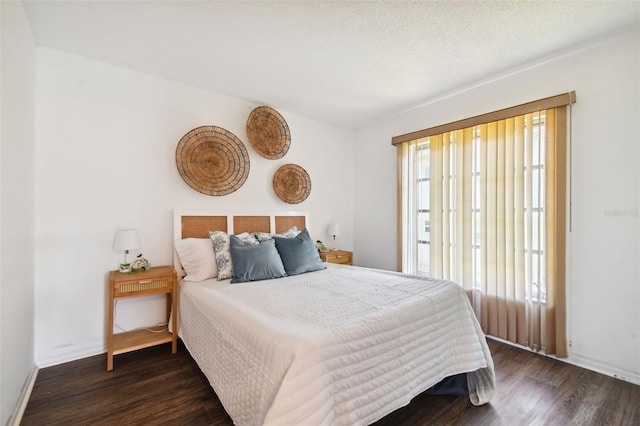 bedroom with a textured ceiling and wood-type flooring