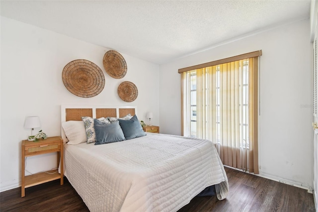 bedroom with a textured ceiling, multiple windows, and hardwood / wood-style flooring